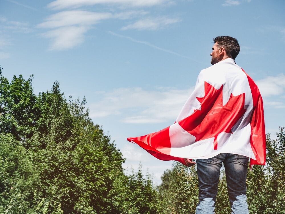 attractive-man-holding-canadian-flag-national-holiday